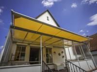 Markise in gelb über Glasüberdachung