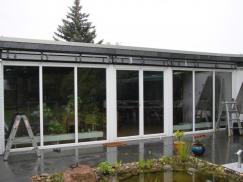 Fensterfront aus Kunststoff in weiß mit Jalousien