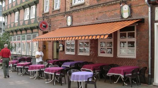 Sprossenfenster in weiß und Markise orange-braun-gestreift  