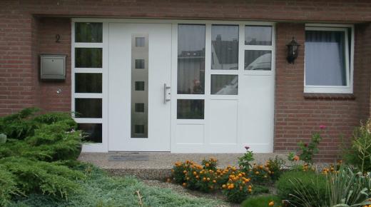 Kunststoff-Haustür in weiß mit Seitenteil links und Treppenlicht rechts