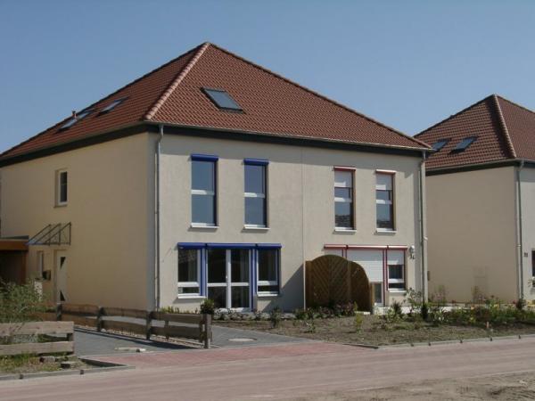 Doppelhaus mit Rollladenkästen in blau und rot