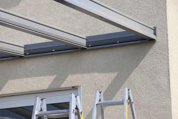 Terrassenüberdachung aus Glas und Aluminium in grau Montage Detailaufnahme