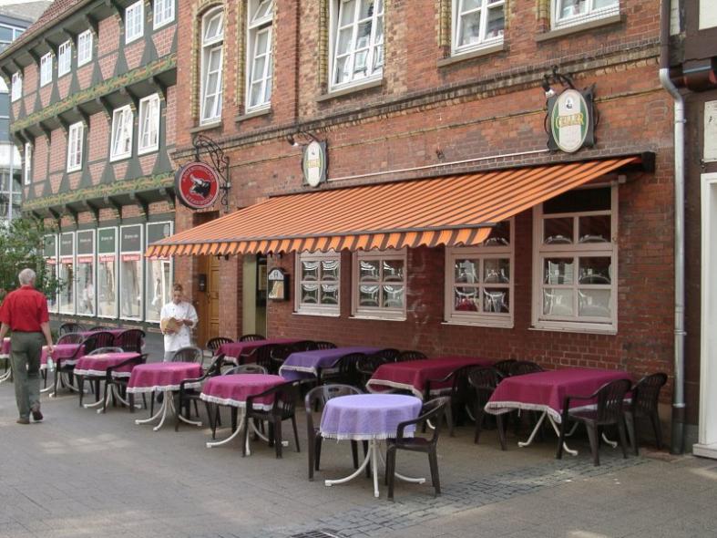 Sprossenfenster in weiß und Markise orange-braun-gestreift  