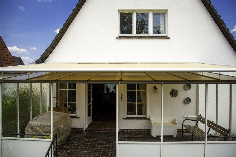 Glasüberdachung mit gelber Markise