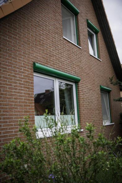 Kunststoff-Fenster in weiß mit grünen Rollladenkästen 