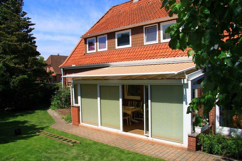 Markise über Wintergarten gelb-weiß-gestreift von Somfy